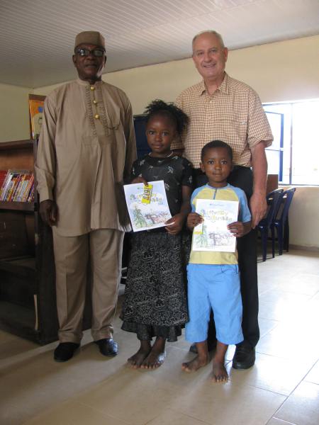 With the school headmaster and two of the children, at a local school where Allyn donated books and crayons