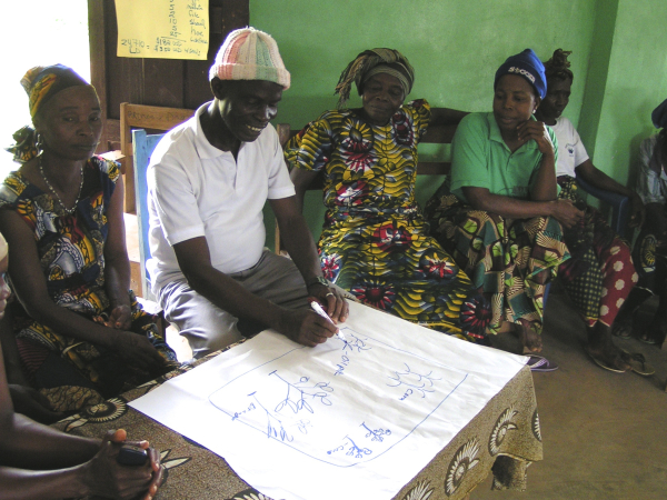 The Zorgowee Village chief, John P. Quoto, prepares a map of his farm.