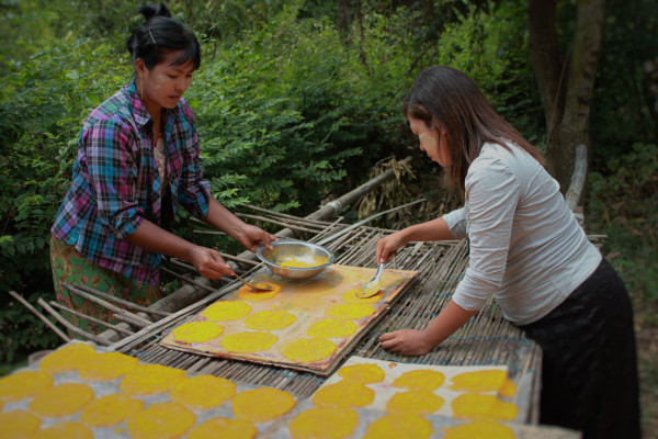 Spooning cooked mango out to dry, the last step in making mango leather. The drying process can take several days, depending on the weather. (Photo: Yee Yee Thant)